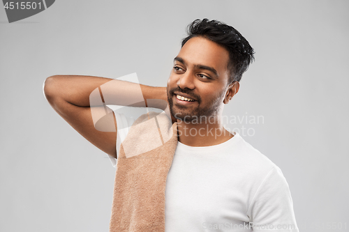 Image of smiling indian man with towel over grey background
