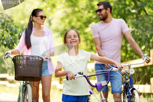 Image of happy family with bicycles in summer park