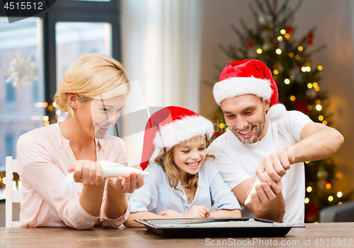 Image of family decorating bakery by frosting on christmas