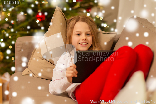 Image of smiling girl with tablet pc at christmas home