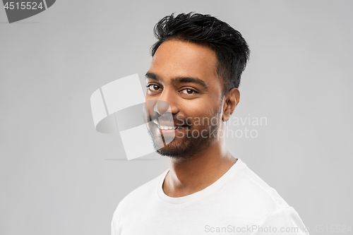 Image of smiling young indian man over gray background