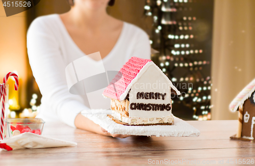 Image of close up of woman with christmas gingerbread house