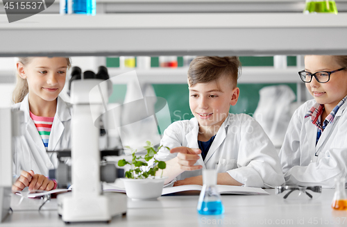Image of kids or students with plant at biology class