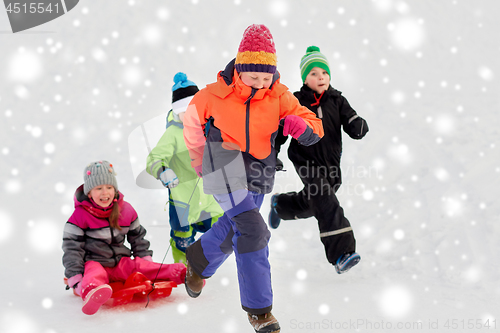 Image of happy kids with sled having fun outdoors in winter