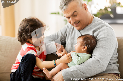 Image of happy father with preteen and baby son at home