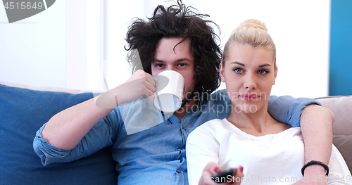 Image of Young couple on the sofa watching television