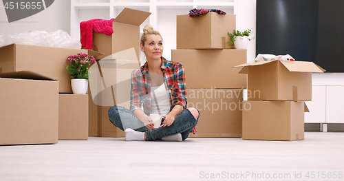 Image of woman with many cardboard boxes sitting on floor