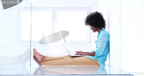 Image of black women using laptop computer on the floor