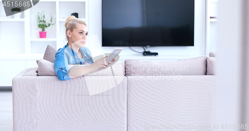 Image of woman on sofa using tablet computer