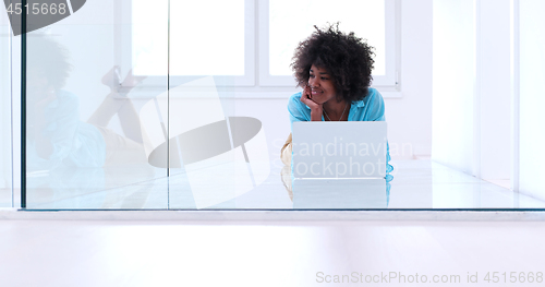 Image of black women using laptop computer on the floor