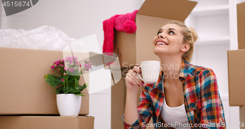 Image of woman with many cardboard boxes sitting on floor