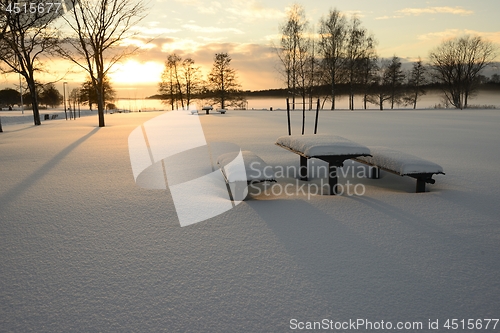 Image of snow covered table and benches outdoors