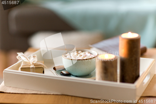 Image of hot chocolate, christmas gift and candles on table