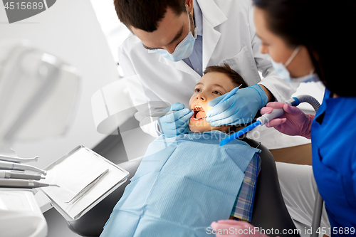 Image of dentist checking for kid teeth at dental clinic