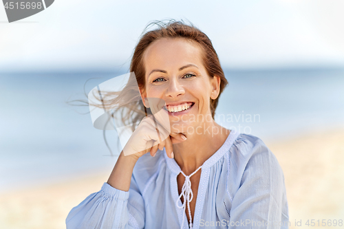 Image of portrait of happy smiling woman on summer beach