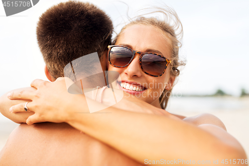 Image of happy couple hugging on summer beach