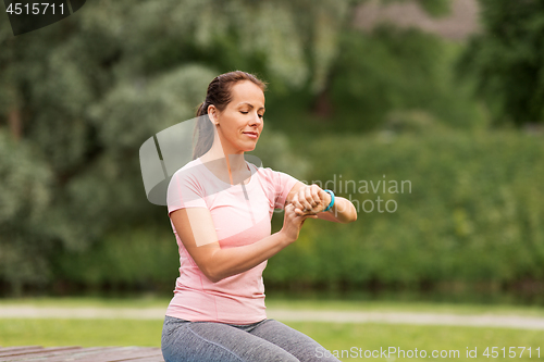 Image of woman with fitness tracker at summer park