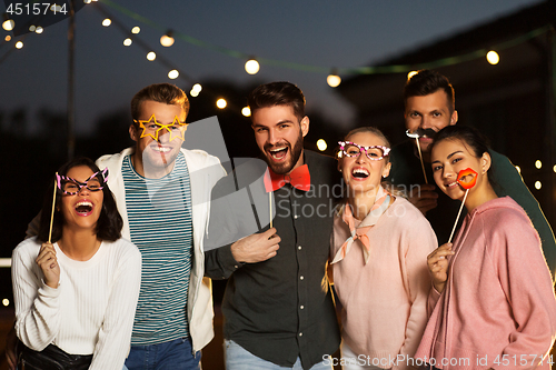 Image of happy friends with party props at rooftop