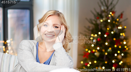 Image of middle aged woman over christmas tree at home