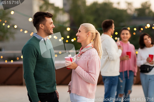 Image of friends with drinks in party cups at rooftop