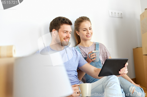 Image of couple with tablet pc computer moving to new home