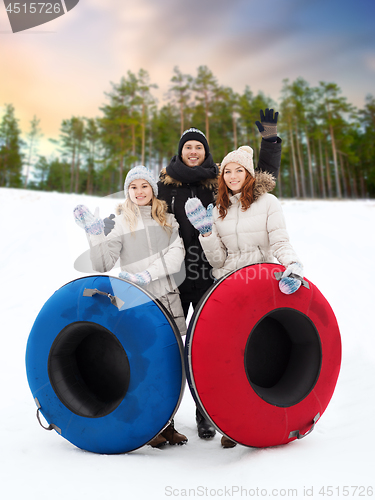 Image of happy friends with snow tubes outdoors in winter