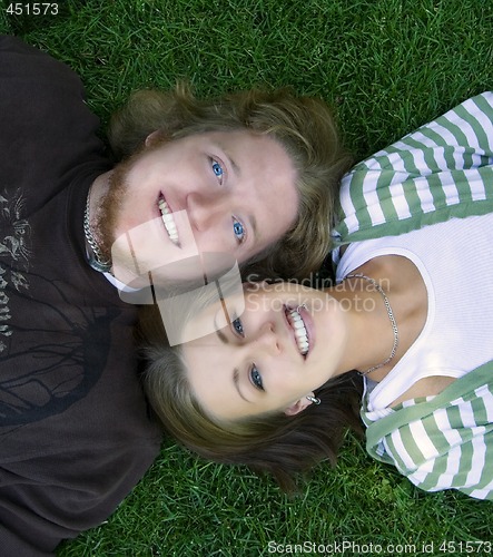 Image of Young couple looking at the camera laying down