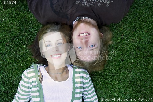Image of Young couple looking at the camera laying down