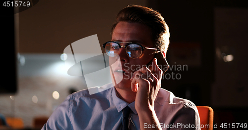 Image of man using mobile phone in dark office