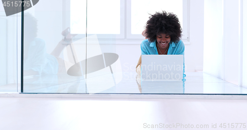 Image of black women using laptop computer on the floor