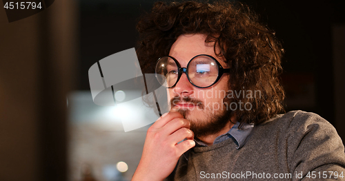 Image of man working on computer in dark office