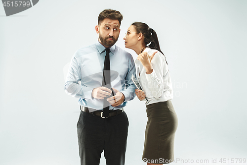 Image of The young woman whispering a secret behind her hand over white background