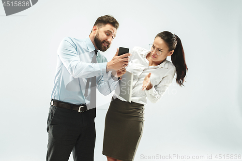 Image of angry businessman and his colleague in the office.