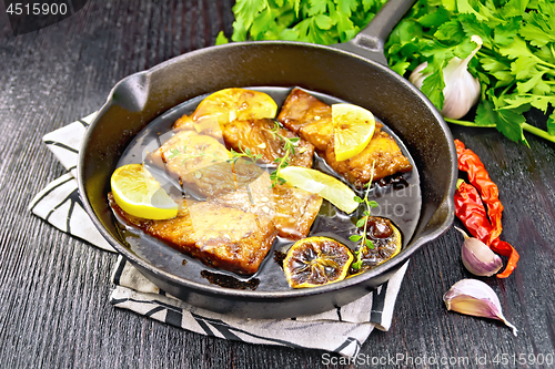 Image of Salmon with sauce in pan on wooden board