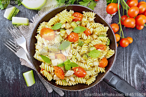 Image of Fusilli with chicken and tomatoes in pan on board top