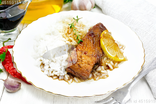 Image of Salmon with sauce and rice in plate on white board