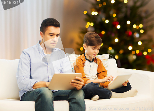 Image of father and son with tablet computers on christmas