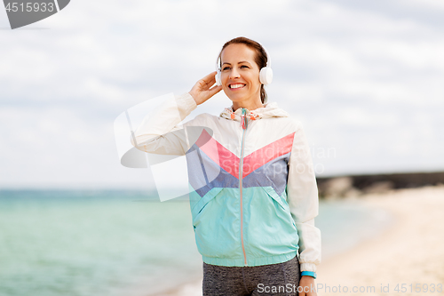 Image of sporty woman with headphones on beach