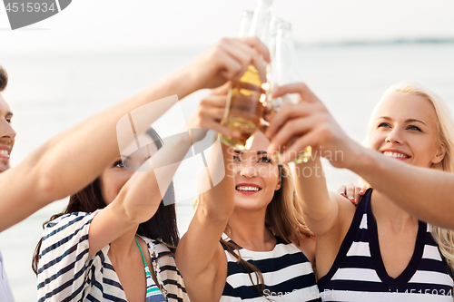 Image of happy friends drinking non alcoholic beer on beach