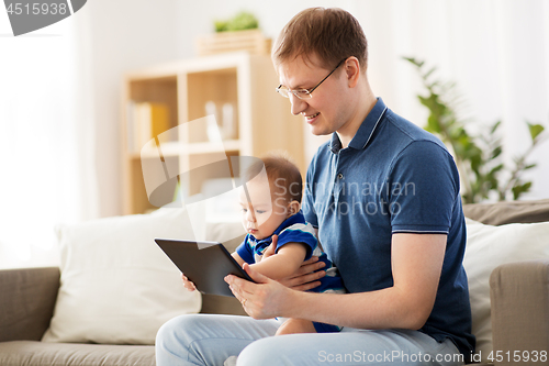 Image of happy father and baby son with tablet pc at home