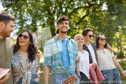 Image of friends with guitar going to picnic at park