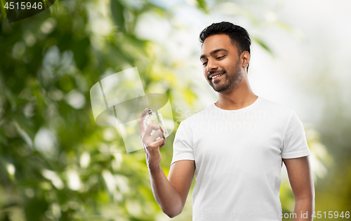 Image of indian man with perfume over natural background