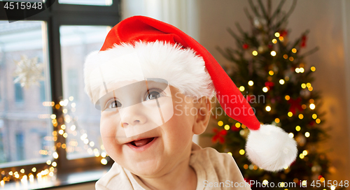 Image of happy little baby boy in santa hat on christmas