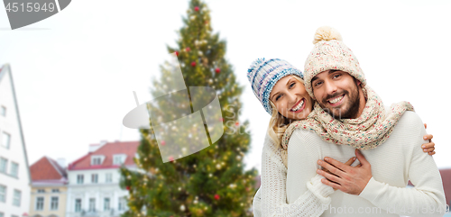 Image of happy couple hugging over christmas tree