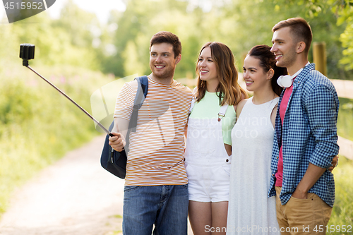 Image of friends take picture by smartphone on selfie stick