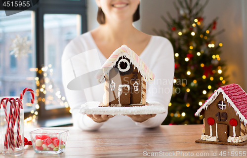 Image of close up of woman with christmas gingerbread house