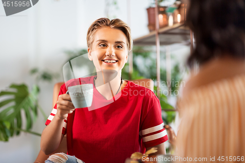 Image of female friends drinking coffee and talking at cafe