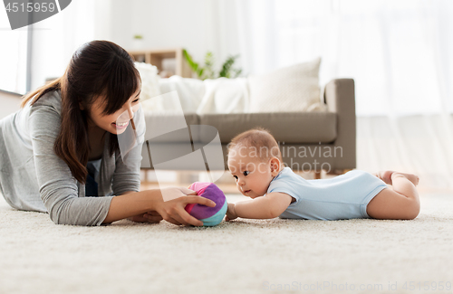 Image of mother and baby son playing with ball at home