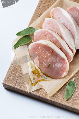 Image of raw pork escalope with sause made of honey and herbs