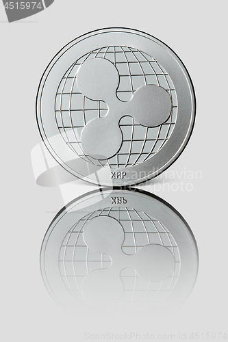 Image of Silver coin ripple on white glossy background.